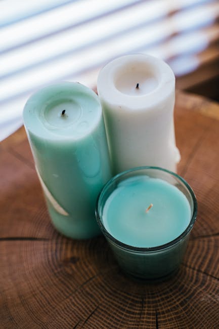 Close-up shot of three candles on a wooden table, creating a warm ambiance.